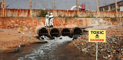 Scientist or biologist wearing protective uniforms analyze the waste water flow to the sea